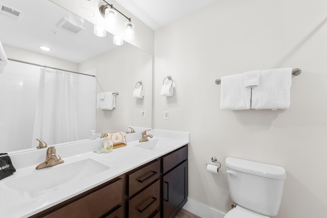 bathroom featuring walk in shower, vanity, and toilet