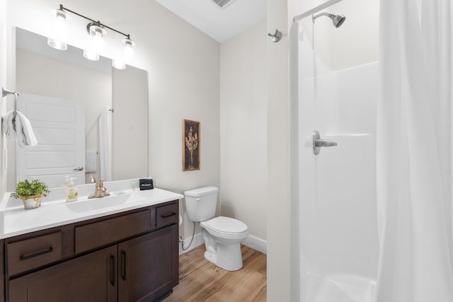 bathroom featuring hardwood / wood-style floors, toilet, a shower with curtain, and vanity