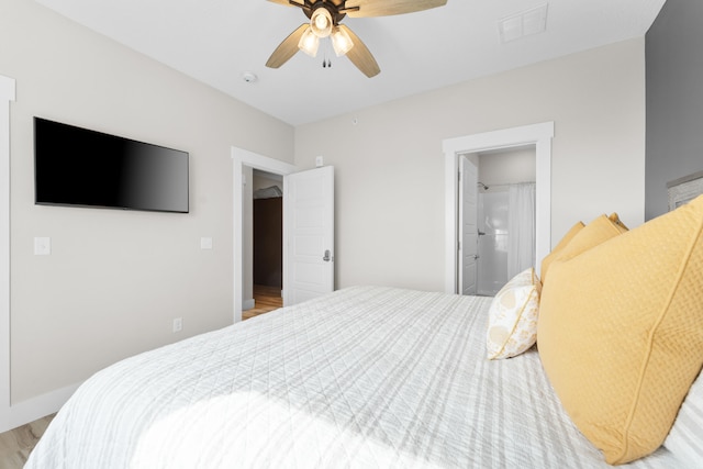 bedroom with connected bathroom, light wood-type flooring, and ceiling fan