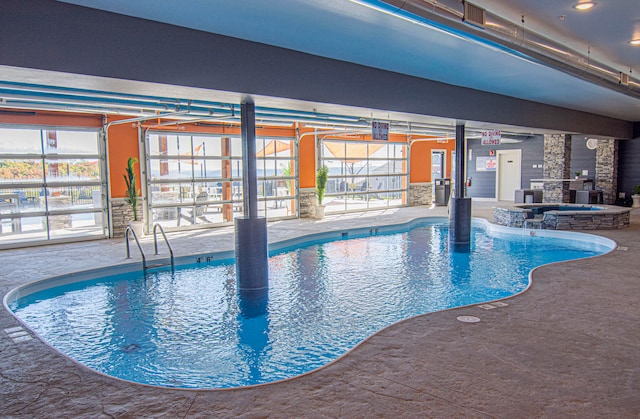 view of swimming pool featuring an indoor in ground hot tub and a patio area