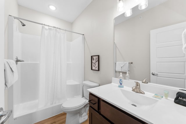 bathroom with wood-type flooring, vanity, toilet, and curtained shower