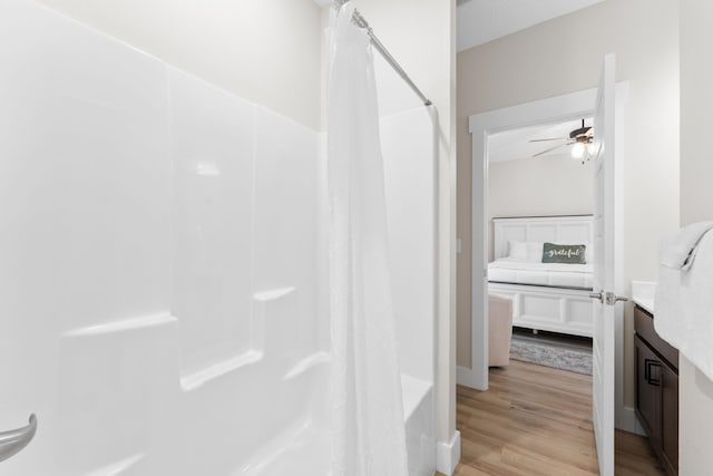 bathroom featuring ceiling fan, shower / bath combination with curtain, vanity, and hardwood / wood-style floors