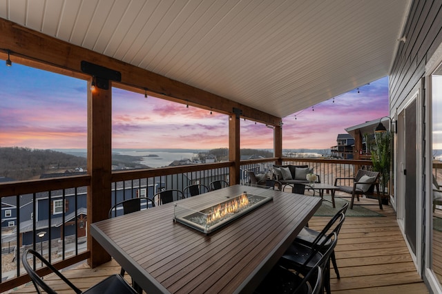 deck at dusk featuring an outdoor living space with a fire pit