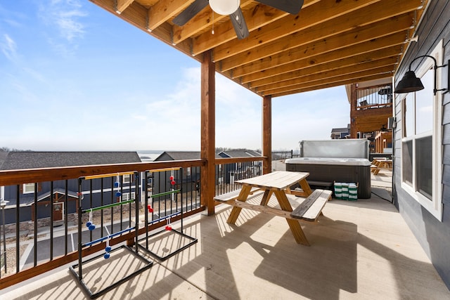 balcony with ceiling fan and a hot tub