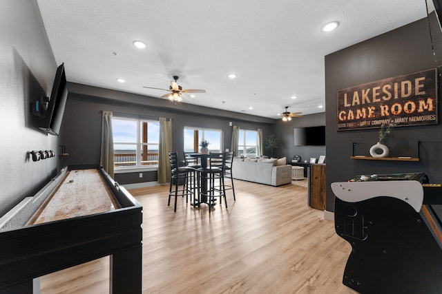 interior space featuring ceiling fan, a textured ceiling, and light hardwood / wood-style floors