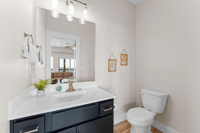 bathroom featuring ceiling fan, hardwood / wood-style floors, vanity, and toilet