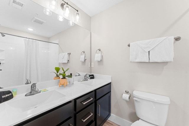 bathroom featuring walk in shower, hardwood / wood-style flooring, vanity, and toilet