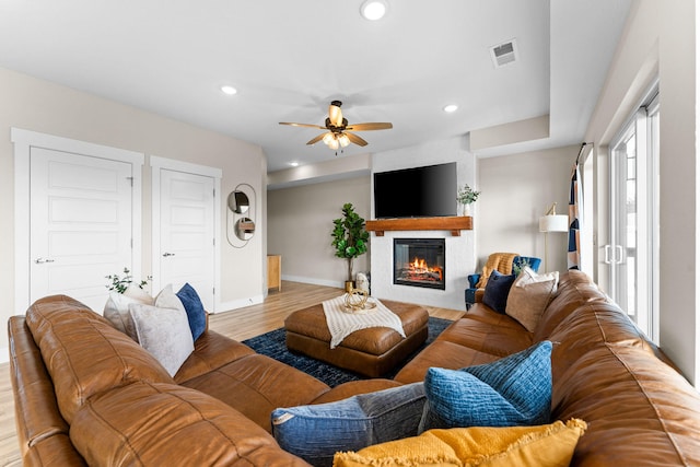 living room featuring light hardwood / wood-style floors and ceiling fan