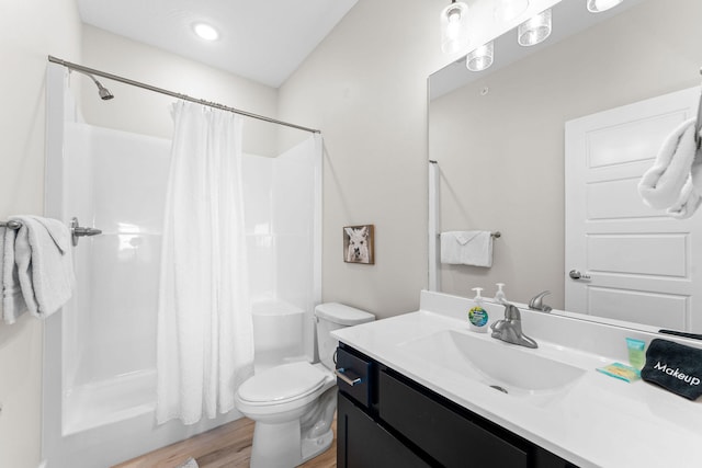 full bathroom with hardwood / wood-style flooring, vanity, shower / bath combo with shower curtain, and toilet