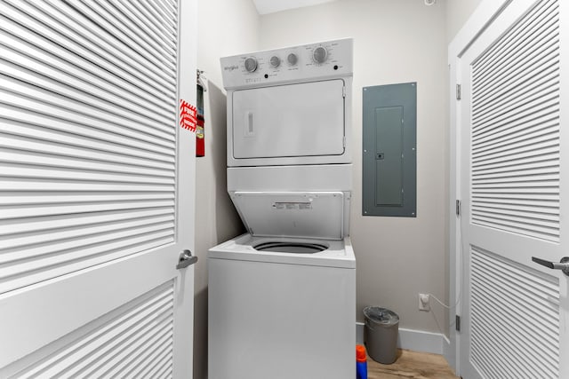 washroom featuring electric panel and stacked washer / drying machine