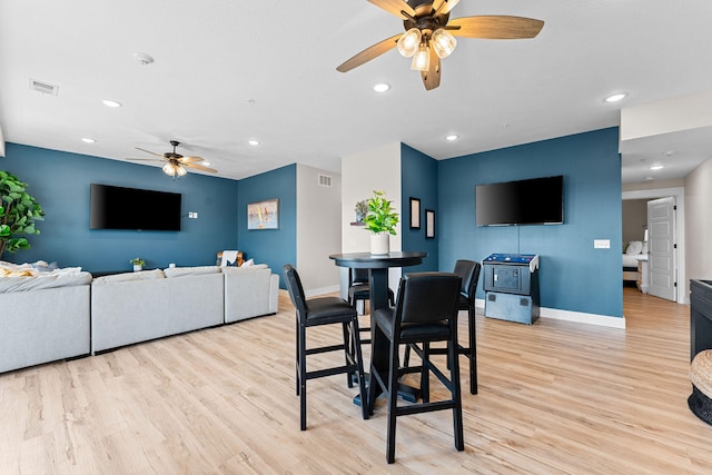 dining area with light wood-type flooring and ceiling fan