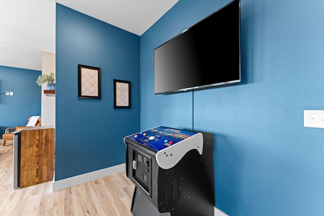 playroom with a textured ceiling and light hardwood / wood-style flooring