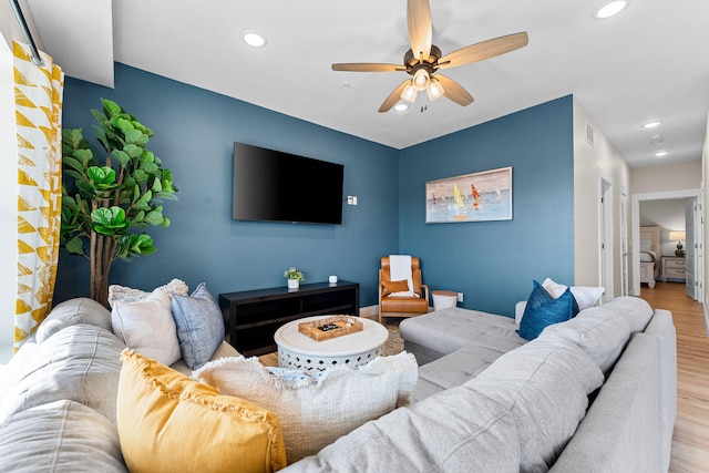 living room with light hardwood / wood-style flooring and ceiling fan