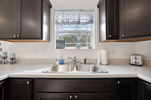 kitchen featuring dark brown cabinets and sink