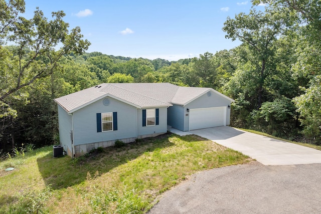 ranch-style home with a garage, a front yard, and central AC