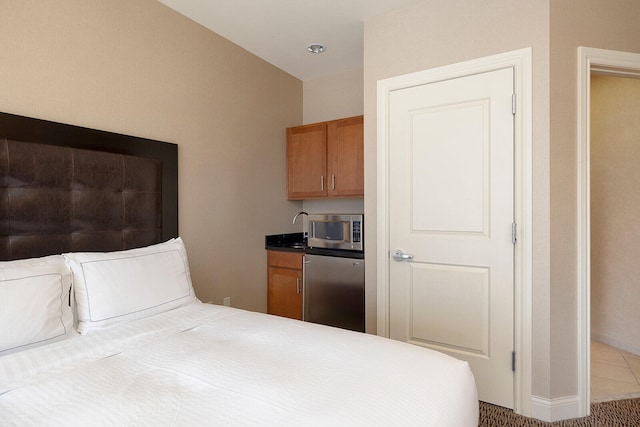 carpeted bedroom with stainless steel refrigerator and vaulted ceiling