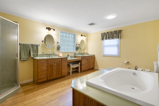 bathroom with ornamental molding, hardwood / wood-style flooring, vanity, and plus walk in shower