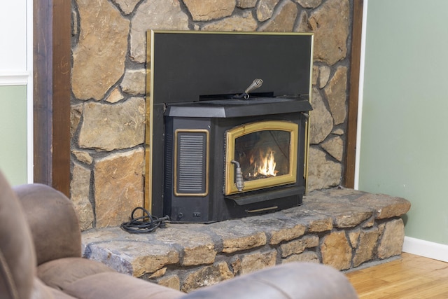 details with baseboards, a wood stove, and wood finished floors
