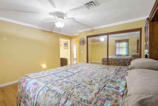 bedroom with ceiling fan, a closet, light hardwood / wood-style flooring, and ornamental molding