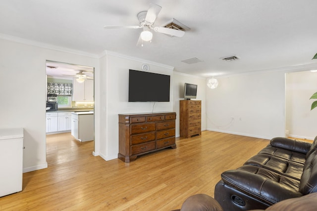 living area with ceiling fan, ornamental molding, visible vents, and light wood-type flooring