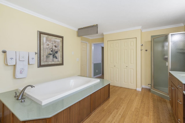 bathroom featuring ornamental molding, separate shower and tub, hardwood / wood-style flooring, and vanity