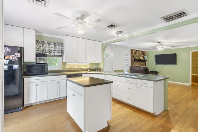 kitchen featuring a peninsula, a ceiling fan, visible vents, and black appliances