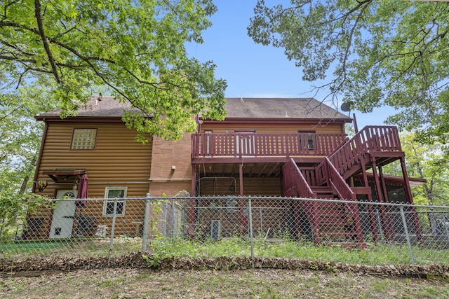 back of house with a wooden deck, fence private yard, roof with shingles, and stairway