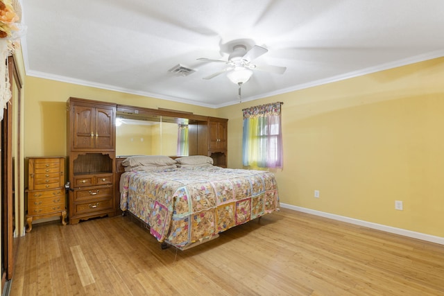 bedroom featuring light wood-type flooring, baseboards, visible vents, a ceiling fan, and ornamental molding