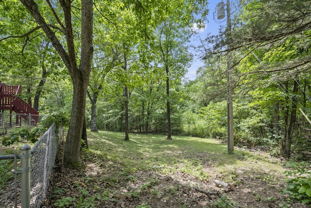 view of yard with fence and a view of trees