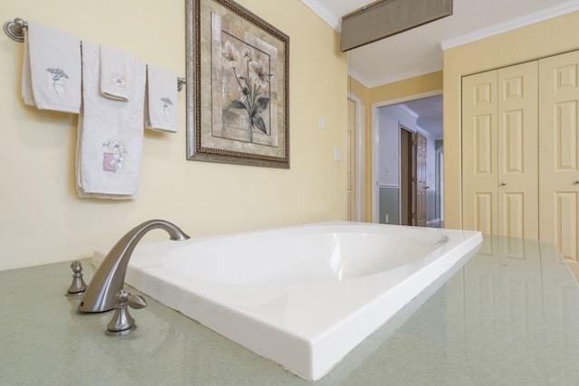 bathroom with a bath and ornamental molding