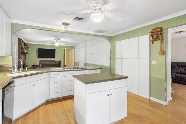 kitchen with a peninsula, a sink, arched walkways, ceiling fan, and appliances with stainless steel finishes