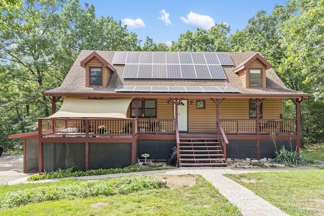 view of front of home with a front lawn, solar panels, and covered porch