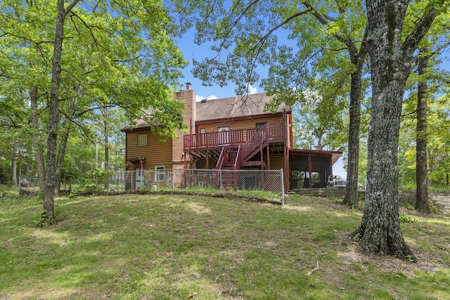 rear view of house with faux log siding, a chimney, fence, stairway, and a deck
