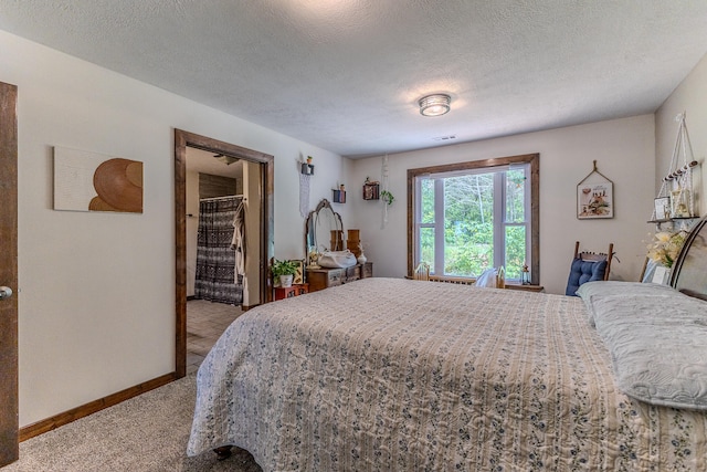 bedroom featuring light colored carpet, a spacious closet, a closet, and a textured ceiling