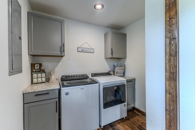 laundry room with electric panel, washer and clothes dryer, dark wood-type flooring, and cabinets