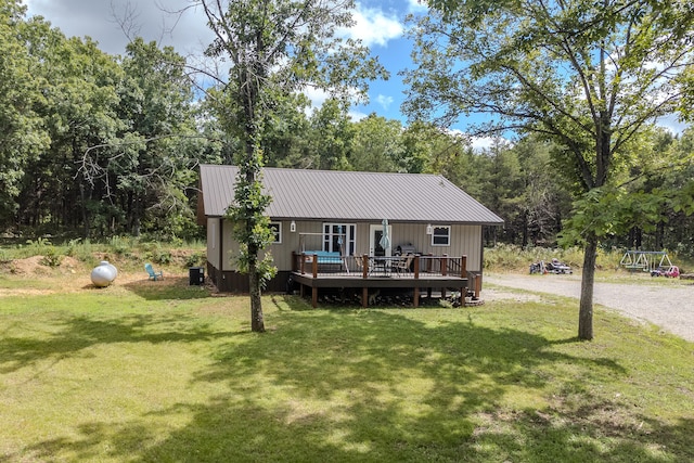 rear view of property with a yard and a deck