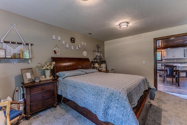 carpeted bedroom featuring a textured ceiling