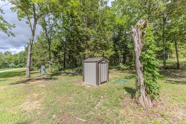 7084 Logan Rd, Hartville, MO 65667 - view of yard featuring a storage unit, an outbuilding, and a wooded view