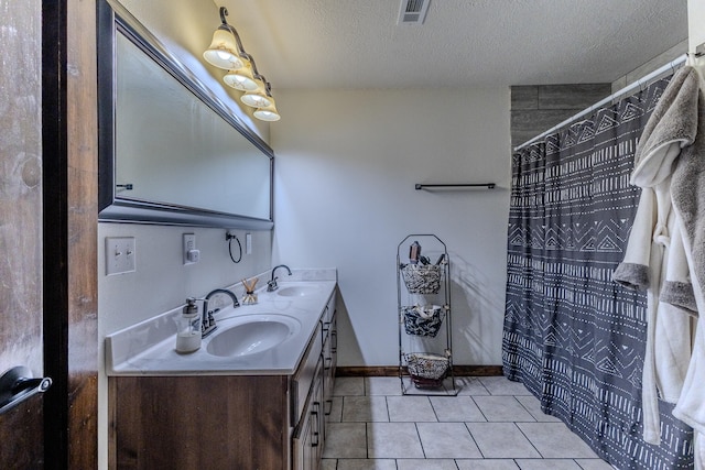 bathroom featuring tile patterned floors, a shower with shower curtain, vanity, and a textured ceiling