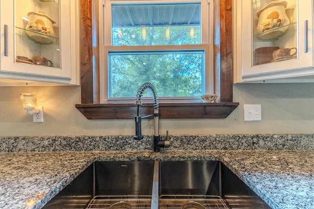 7084 Logan Rd, Hartville, MO 65667 - details with white cabinets, glass insert cabinets, a sink, and dark stone countertops