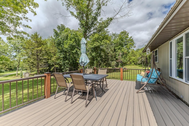 7084 Logan Rd, Hartville, MO 65667 - wooden deck with outdoor dining space, a lawn, a shed, and an outbuilding