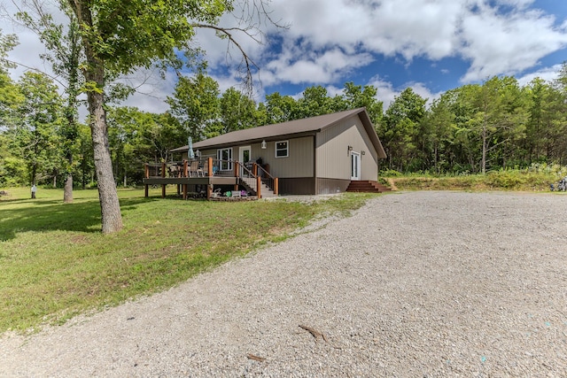 7084 Logan Rd, Hartville, MO 65667 - view of front of property with gravel driveway, a deck, and a front lawn
