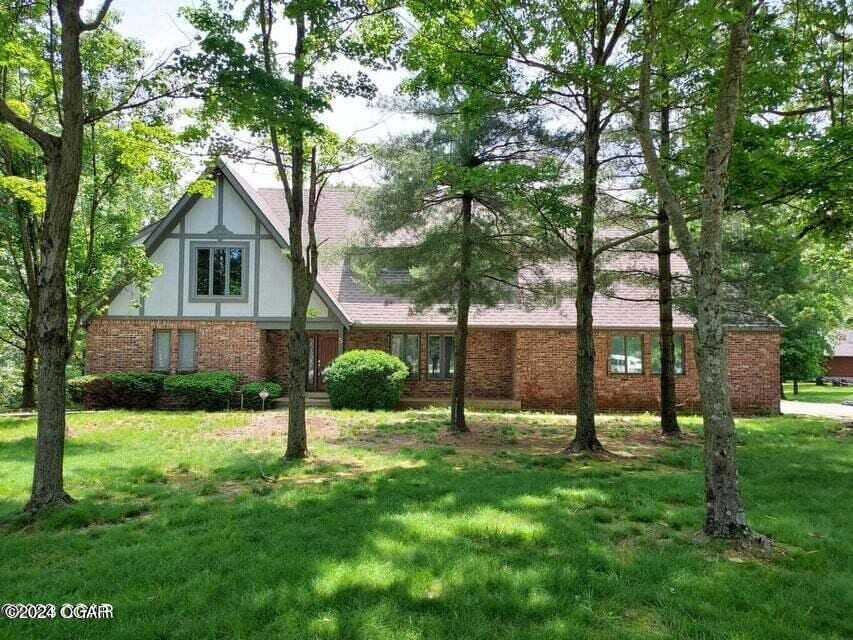 tudor home featuring brick siding and a front yard