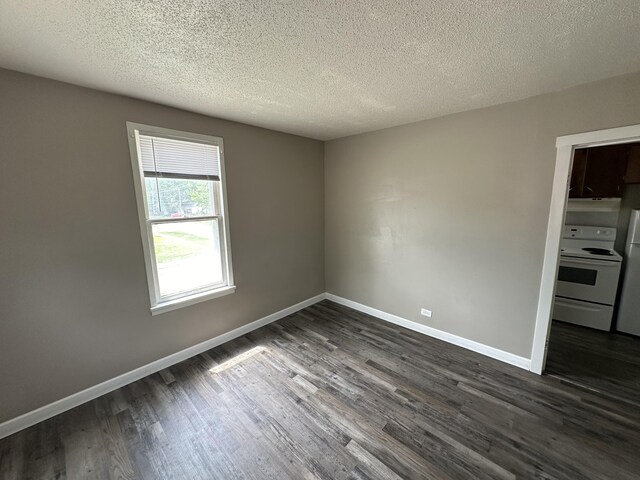 unfurnished room with a textured ceiling and dark hardwood / wood-style flooring