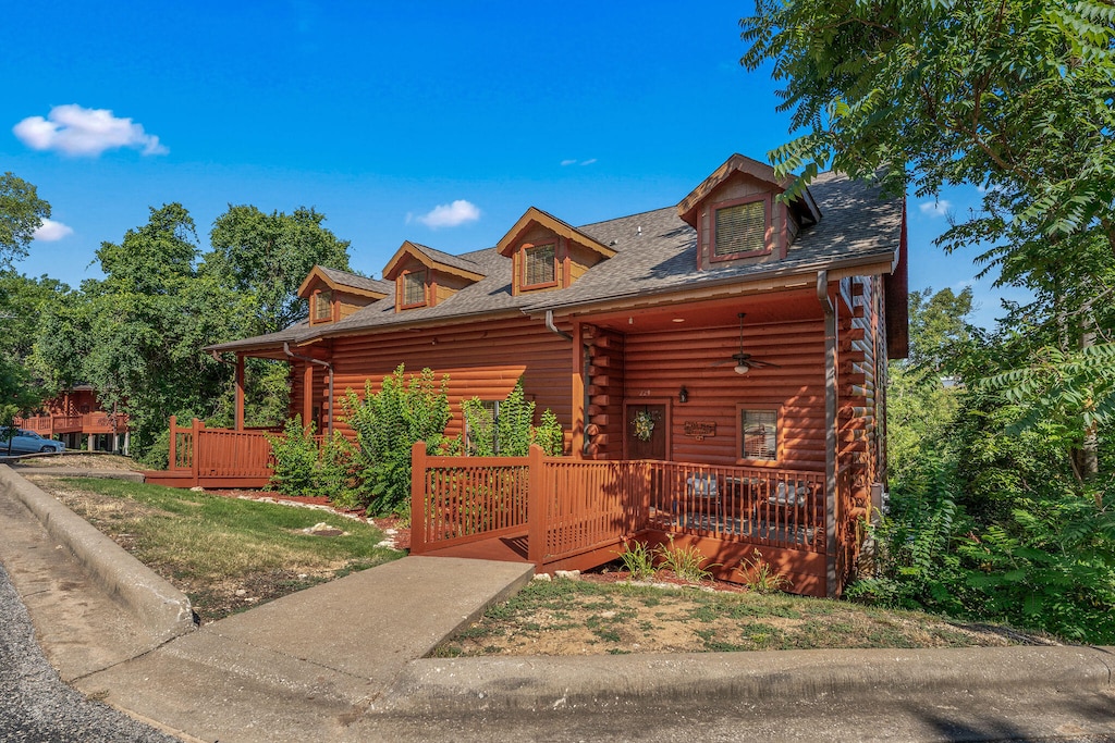 log home with a front lawn and covered porch