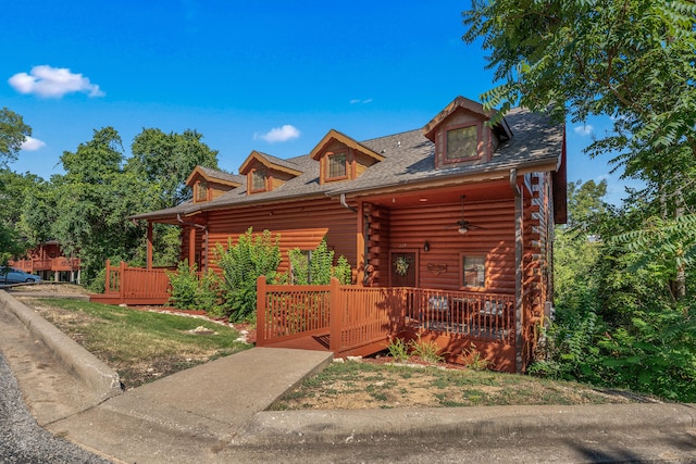 log home with a front lawn and covered porch