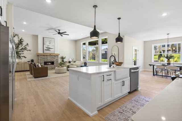 kitchen featuring a wealth of natural light, white cabinetry, and a center island with sink