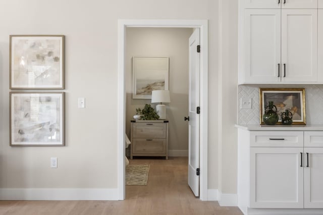 hallway with light hardwood / wood-style floors