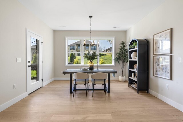 dining room with light hardwood / wood-style floors and a chandelier