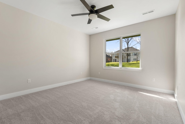 carpeted spare room featuring ceiling fan